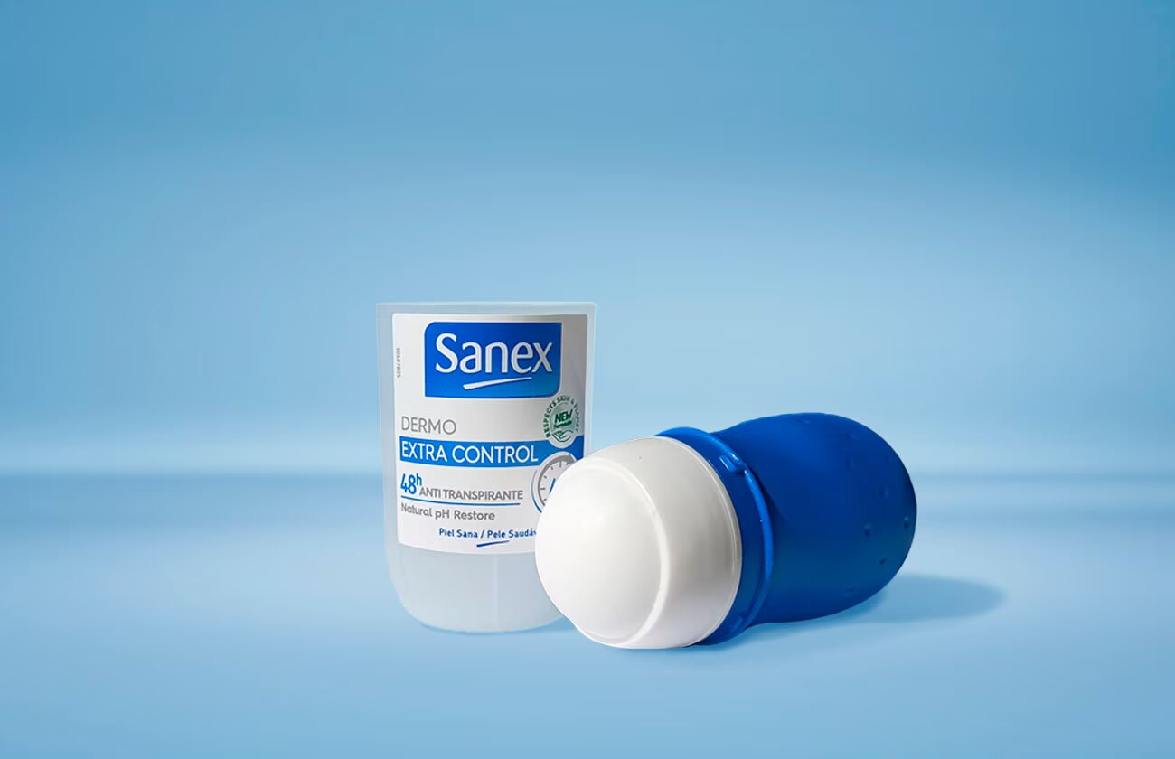 Een Sanex Dermo Extra Control roll-on deodorant die rechtop staat, met een tweede deodorant ernaast die op zijn kant ligt en de rollerbal toont, tegen een blauwe achtergrond.